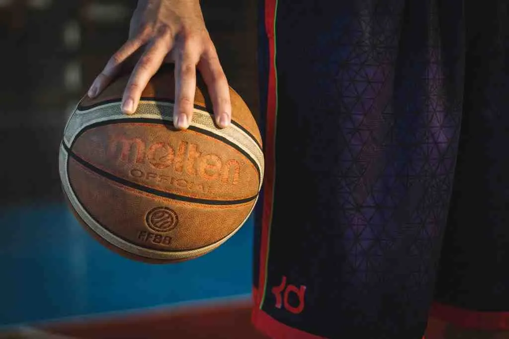 a person holding a basketball and wearing a knee brace for basketball